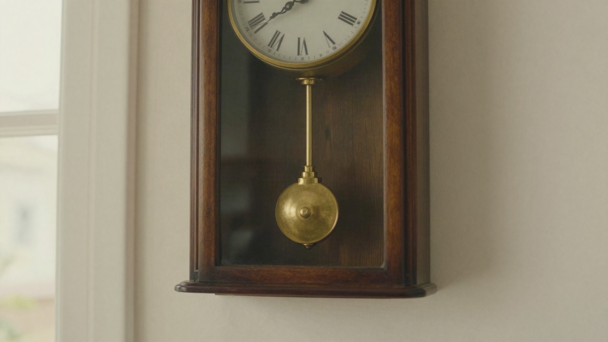 Péndulo de latón de un reloj de pared antiguo en pleno movimiento
